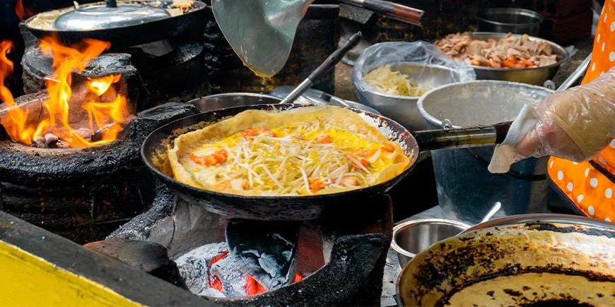 Bánh xèo wird über glühender Holzkohle zubereitet