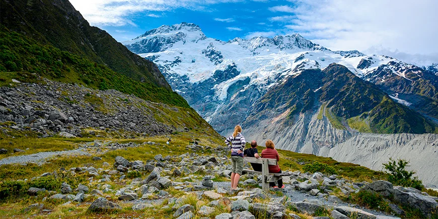 Eine dreiköpfige Familie betrachtet die Berge vom Aussichtspunkt Kea Point im Mount-Cook-Nationalpark aus