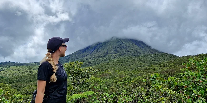 Nadia von TourCompass vor dem Vulkan Arenal an einem bewölkten Tag in Costa Rica