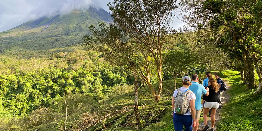 Eine Gruppe von Reisenden wandert auf einem Pfad in Richtung des Vulkans Arenal in Costa Rica
