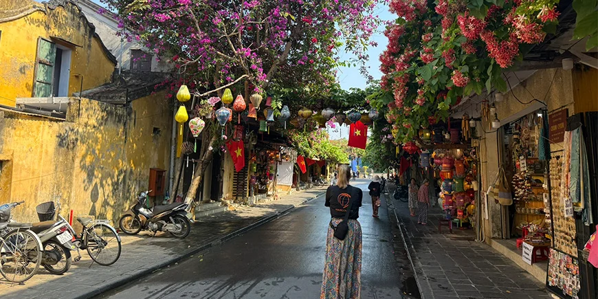 Eine Frau in einem TourCompass-T-Shirt spaziert durch die Altstadt von Hoi An in Vietnam