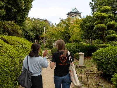 Japanischer Reiseführer und TourCompass-Mitarbeiter machen einen Spaziergang in Osaka, Japan