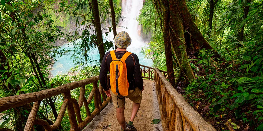 Mann geht die Treppe zum La Fortuna-Wasserfall hinunter