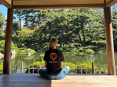 Frau in einem TourCompass-T-Shirt in einem wunderschönen japanischen Garten in Hiroshima