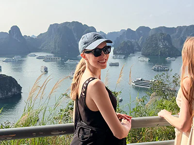 Iida blickt mit dem Rücken zur Halong-Bucht in die Kamera