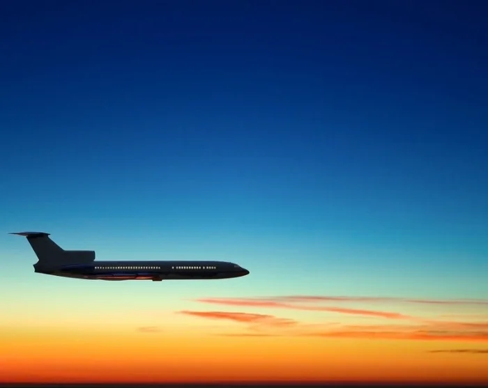 Flugzeug am Himmel bei Sonnenuntergang