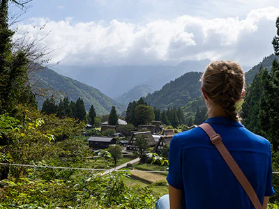 Frau mit Blick auf das malerische Dorf Gokayama