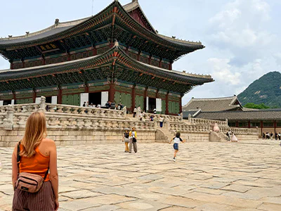 Frau betrachtet den Gyeongbokgung-Palast in Seoul