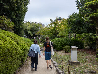 Japanischer Guide spaziert mit einem TourCompass-Mitarbeiter am Osaka Castle in Japan