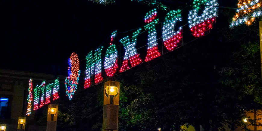Ein Schild, das im Dunkeln leuchtet und auf dem „Vive México“ in den Farben der mexikanischen Flagge steht