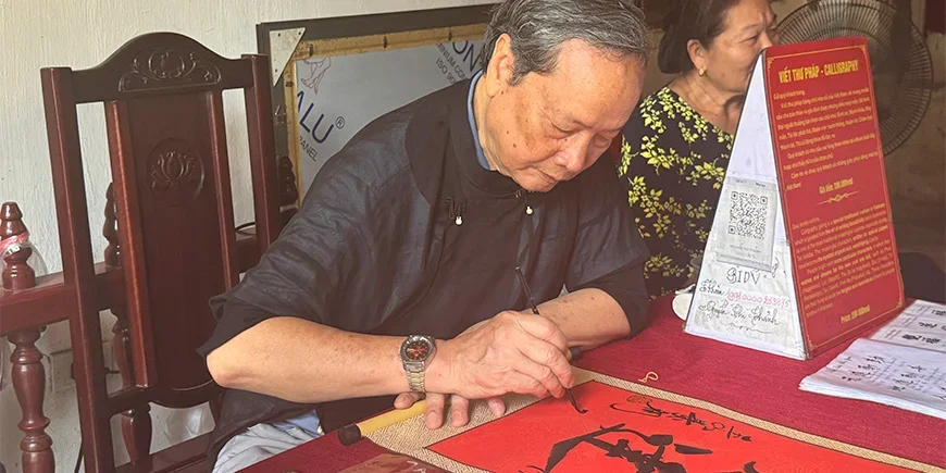 Vietnamesischer Mann, der Kalligrafie ausführt