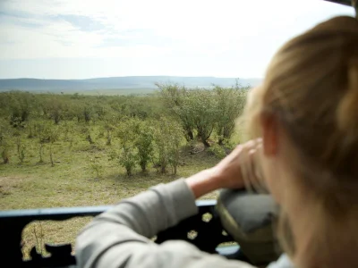 Frau fotografiert einen Geparden in der Masai Mara