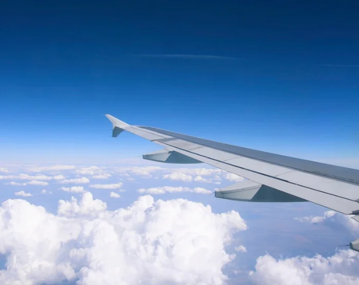 Flugzeugflügel über den Wolken auf dem Weg zum Reiseziel
