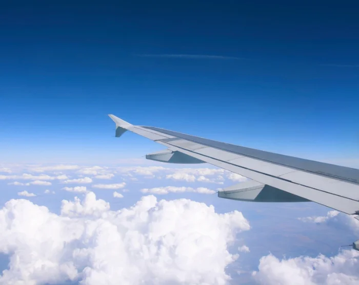 Flugzeugflügel über den Wolken auf dem Weg zum Reiseziel