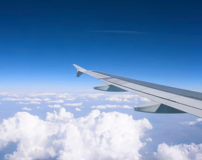 Flugzeugflügel über den Wolken auf dem Weg zu Ihrem Reiseziel