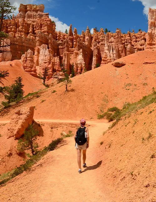 Eine Person wandert auf einem Pfad zwischen den markanten orangefarbenen Felsformationen im Bryce-Canyon-Nationalpark in Utah