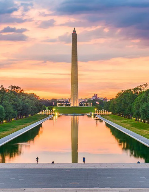 Das Washington Monument am Reflecting Pool in Washington, D.C., USA, in der Morgendämmerung.
