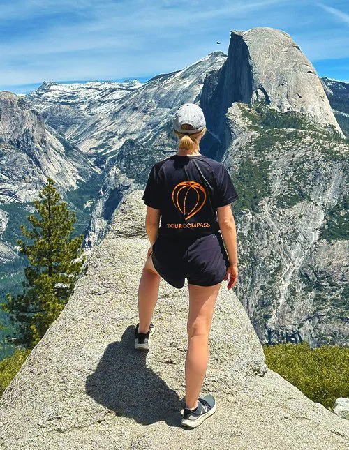 Person in einem TourCompass-T-Shirt, die die Aussicht auf die Berge in den USA genießt