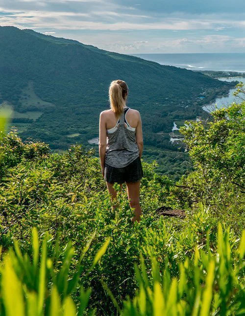 Eine Frau blickt über Le Morne Brabant auf Mauritius.