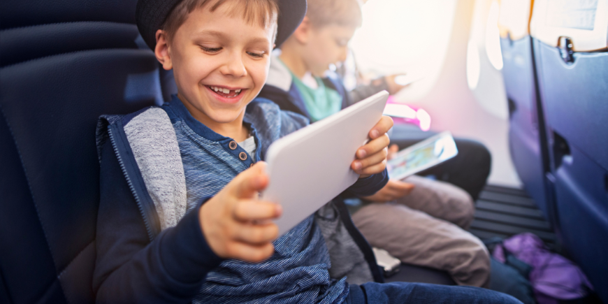 Kinder spielen im Flugzeug mit einem iPad