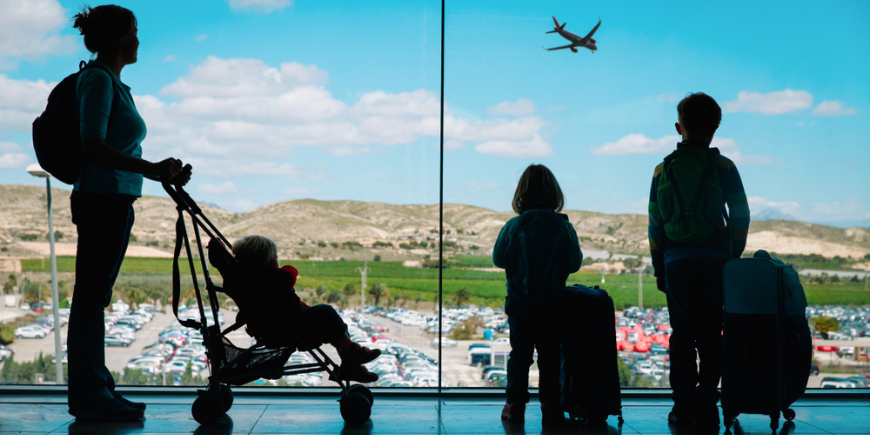 Mama wartet mit den Kindern am Flughafen