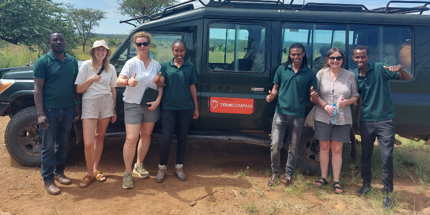 Safari-Reisende und Guides am Safariauto in Afrika