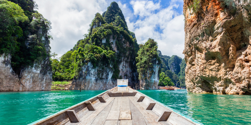 Traditionelles Langboot und wunderschöner Blick auf die Landschaft am Ratchaprapha-Staudamm im Nationalpark Khao Sok.