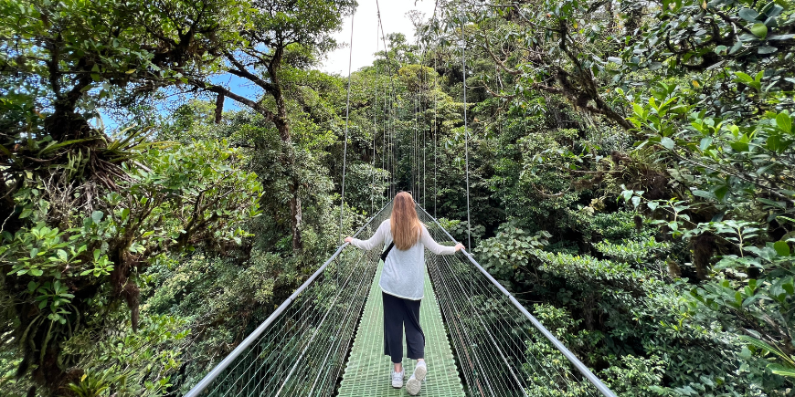 Frau steht auf einer Hängebrücke in Monteverde, Costa Rica