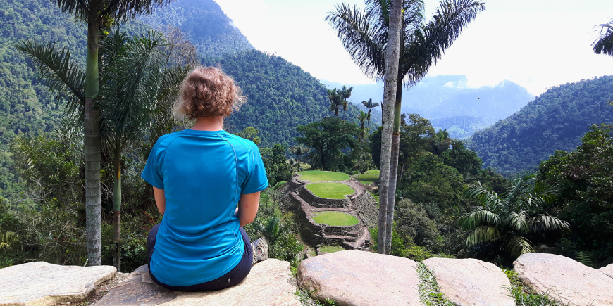 Sitzende Frau mit Blick auf La Ciudad Perdida in Kolumbien