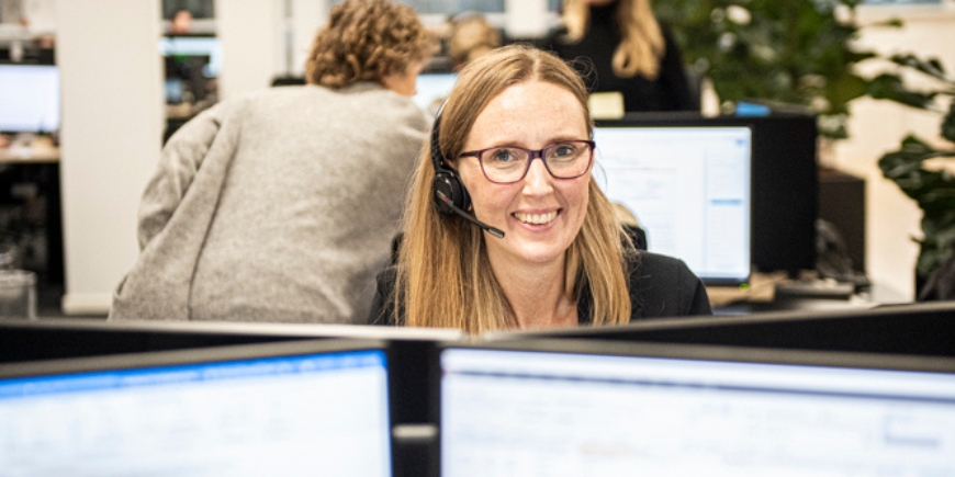 Reisespezialist mit Headset arbeitet an einer Support-Hotline in einem modernen Büro