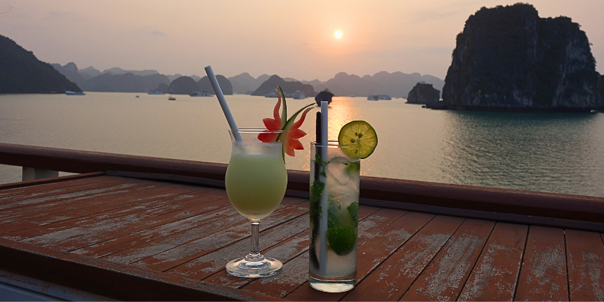 Getränk bei Sonnenuntergang am Kreuzfahrtschiff in der Halong-Bucht