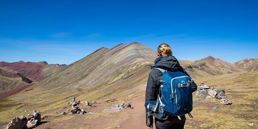 Frau wandert in den Regenbogenbergen von Peru