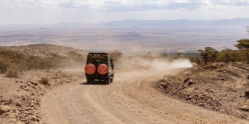 TourCompass-Auto auf einer unbefestigten Straße in Tansania