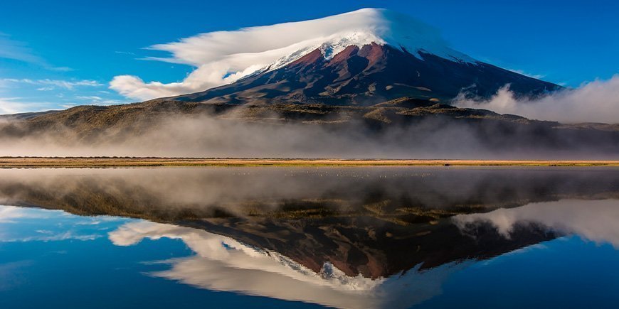 Der Vulkan Cotopaxi in Ecuador spiegelt sich im Wasser