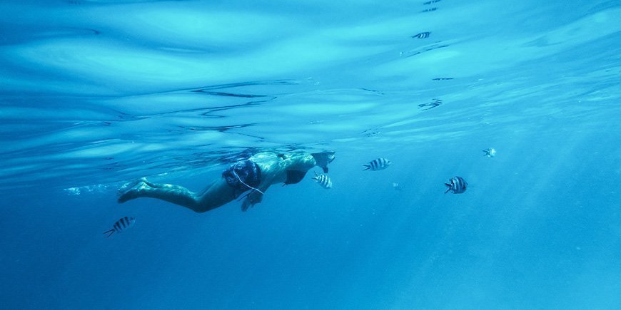 Frau schnorchelt unter Wasser in Sansibar