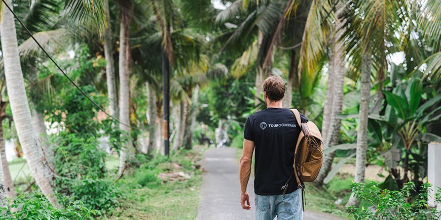 Mann spaziert unter Palmen in Bali, Indonesien