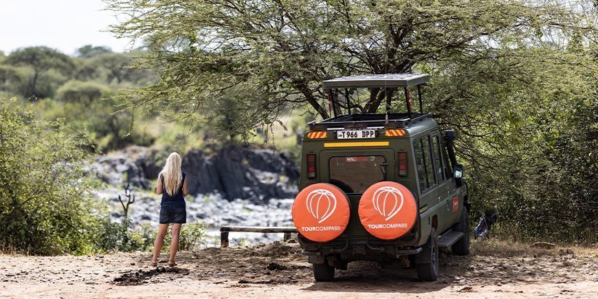 Frau und TourCompass-Jeep in Tansania