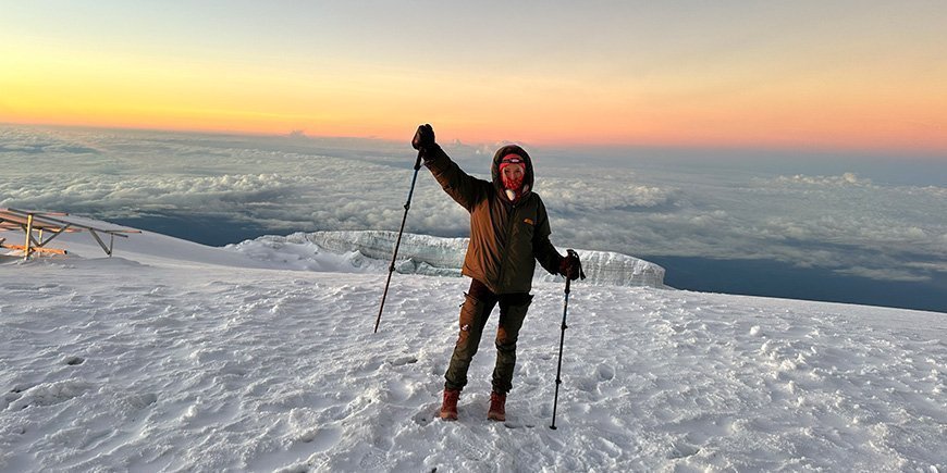 Frau im Schnee auf dem Gipfel des Kilimandscharo.