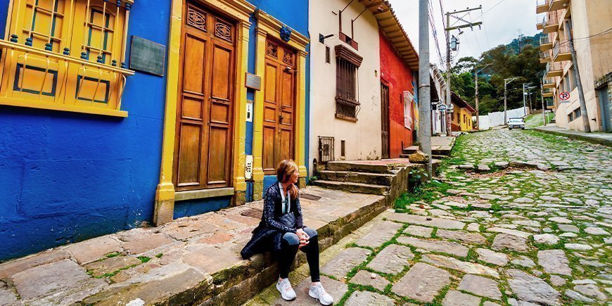 Frau sitzt auf der Straße in La Candelaria in Bogotá, Kolumbien