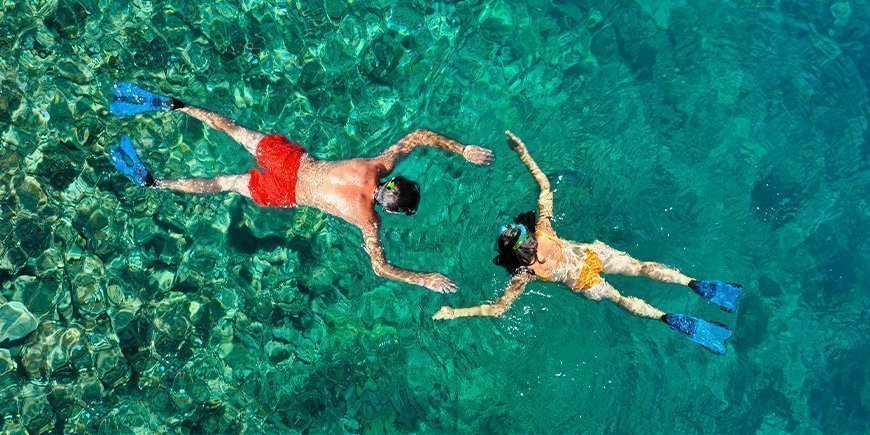 Pärchen beim Schnorcheln im klaren Wasser in Thailand