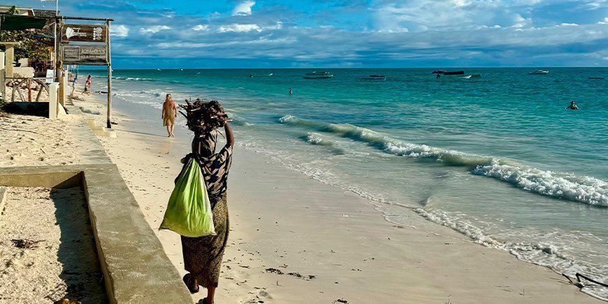 Einheimische Frau beim Spaziergang am Strand von Paje