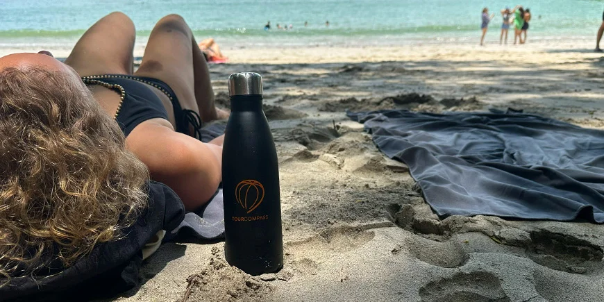 Frau liegt an einem sonnigen Tag am Strand in Costa Rica im Sand.