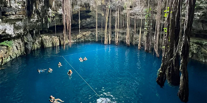 Gruppe von Menschen, die im wunderschönen Cenote Oxman in Mexiko schwimmt