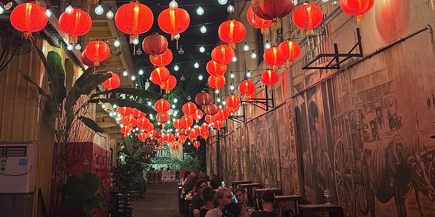 Rote Laternen und Menschen, die im Kwai Chai Hong in Chinatown, Kuala Lumpur, essen