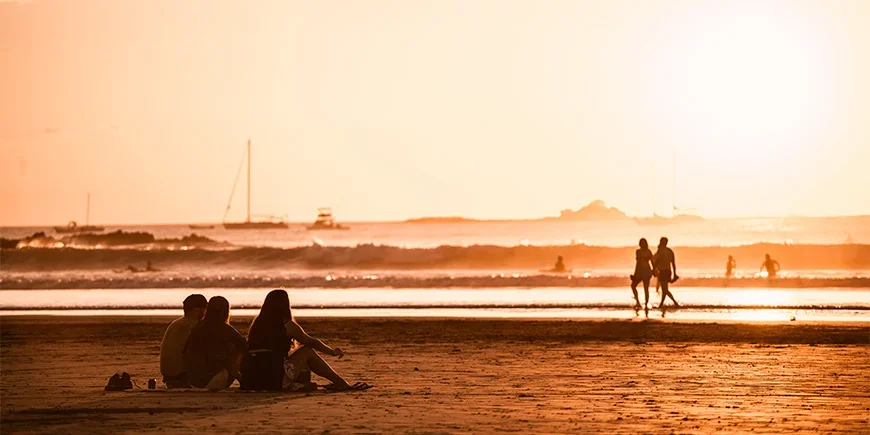 Menschen genießen den Sonnenuntergang am Strand von Tamarindo in Costa Rica
