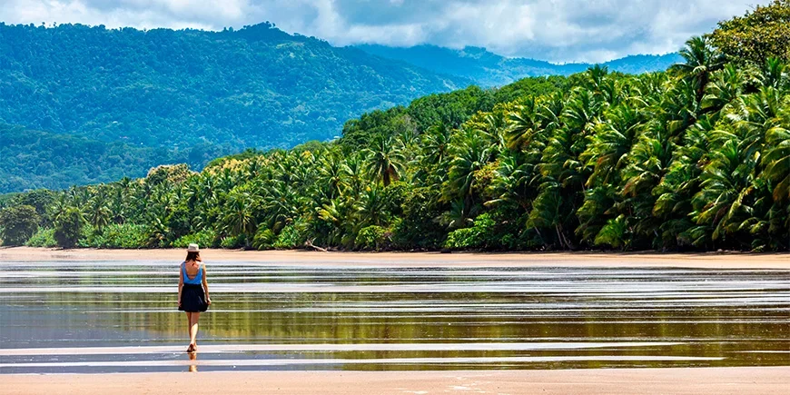 Frau, die am Wasser am Strand von Manuel Antonio in Costa Rica entlangläuft