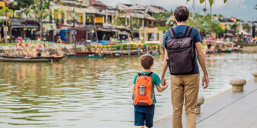 Vater und Sohn gehen Hand in Hand in Hoi An