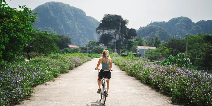 Frau radelt auf einer ruhigen Straße in Ninh Binh, Vietnam