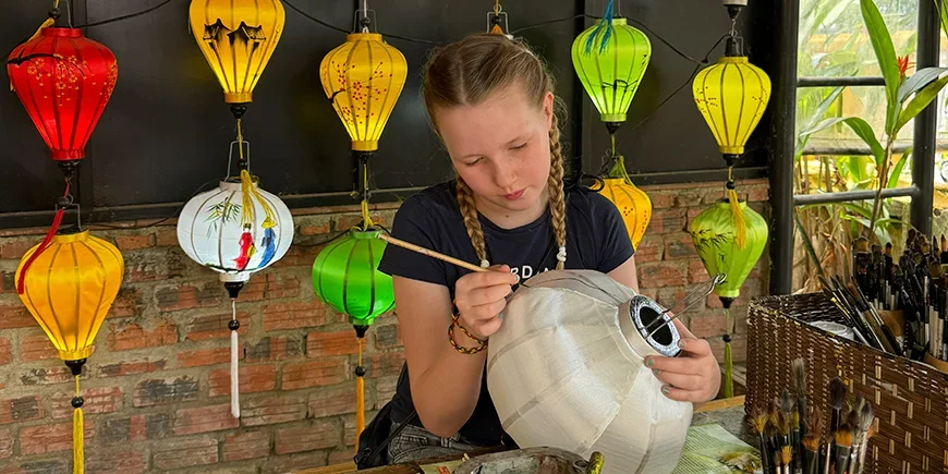 Mädchen bemalt Laternen in Hoi An, Vietnam