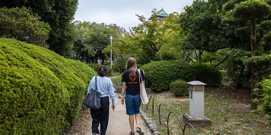 Japanischer Guide spaziert mit einem TourCompass-Mitarbeiter am Osaka Castle in Japan